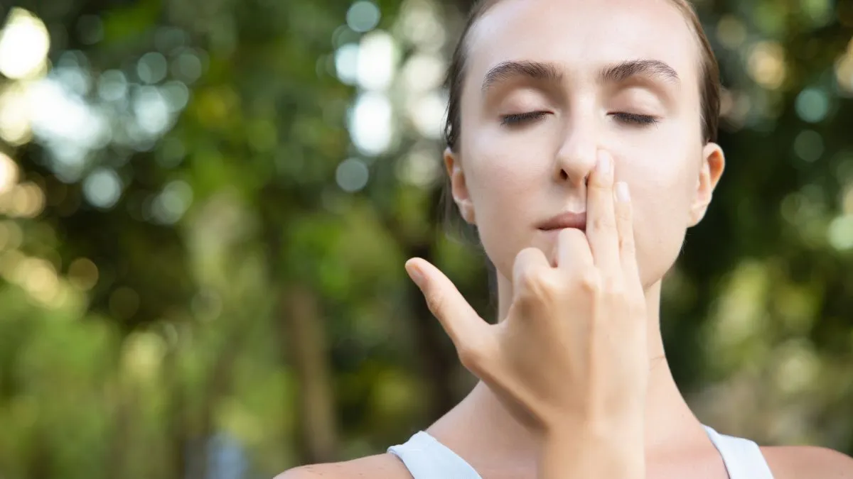 Pranajama – oddech naprzemienny wykonywany przez kobietę z zatkaną jedną dziurką nosa.