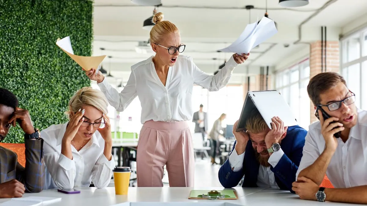 Krzycząca szefowa i przeciążeni pracownicy — ilustracja toksycznej relacji i wampiryzmu energetycznego w biurze